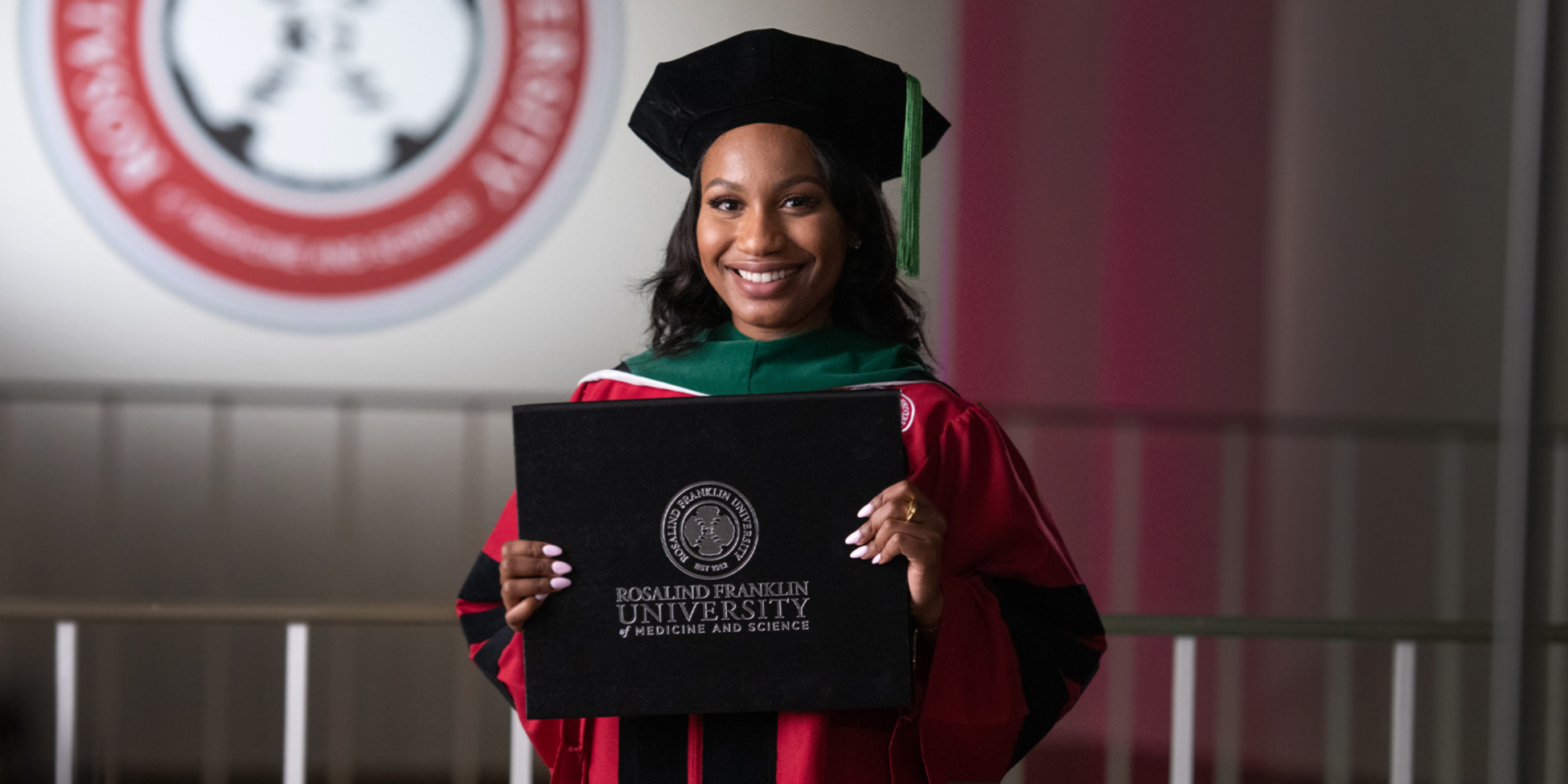 student in regalia with diploma