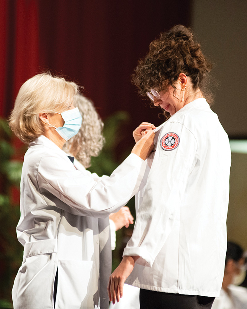 Brenda Affaniti, MD, FACP, pins CMS student Angelica Arzuaga during the Class of 2026 White Coat Ceremony.