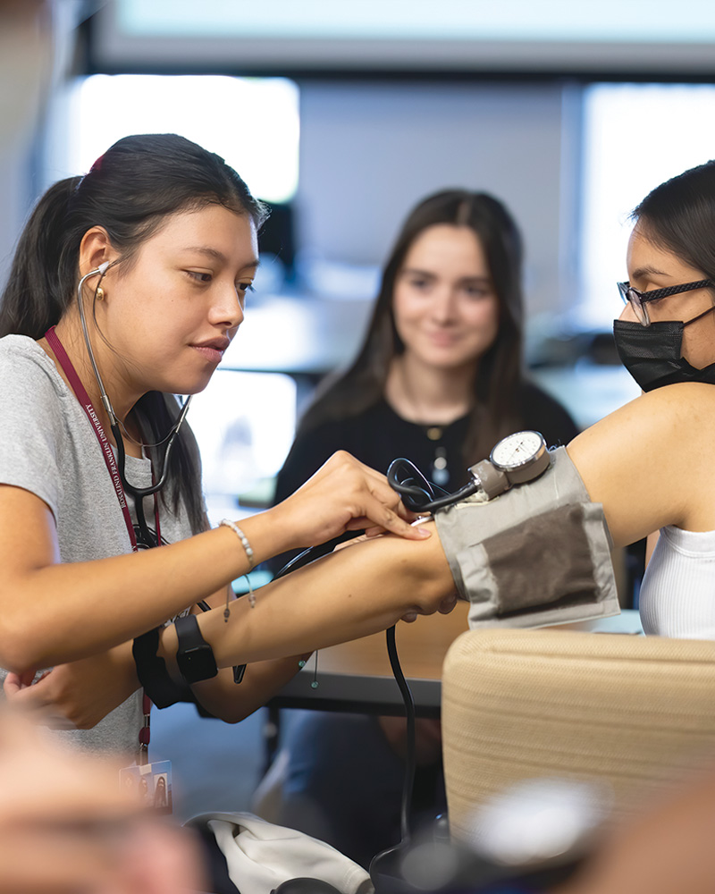 INSPIRE student Sarah Mata demonstrating how to check blood pressure.