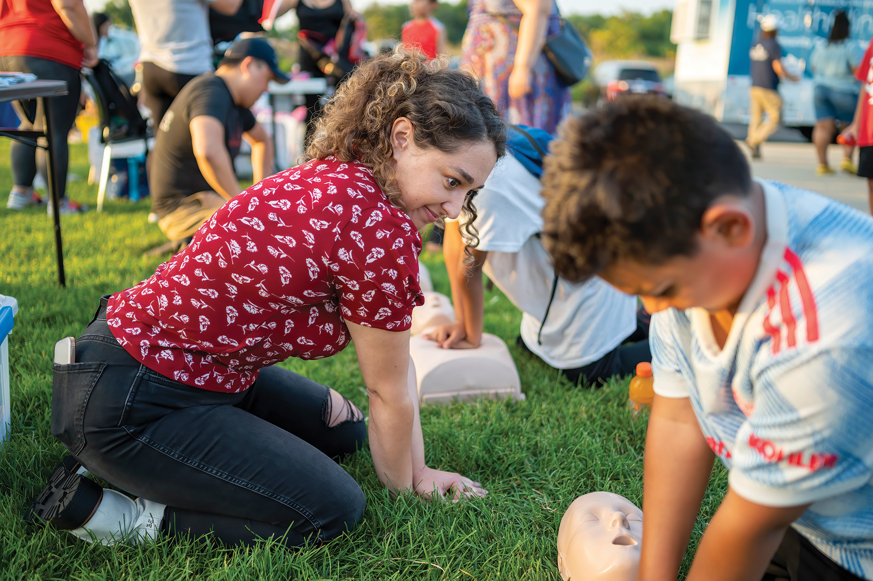 Student showing how to do CPR at an offsite community event.
