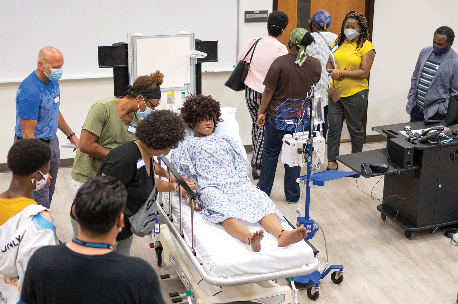 Community members tour a simulation lab looking at mannequin.